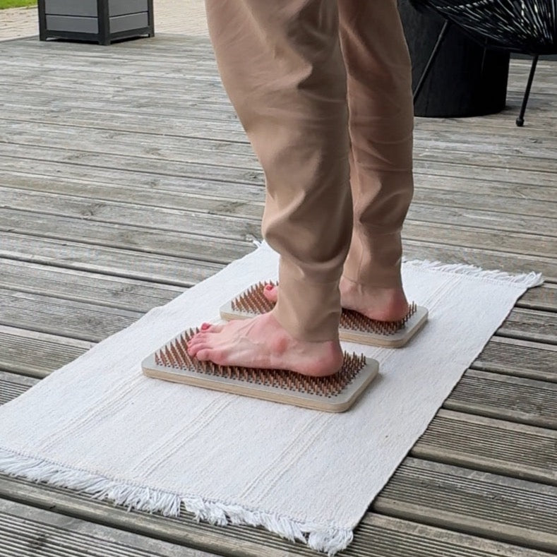 A person standing on the Sadhu board during meditation practice.