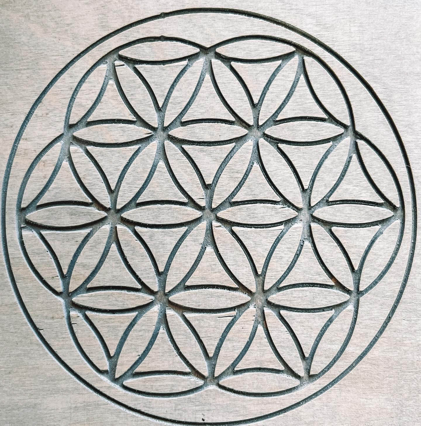 Detailed engraving of the Flower of Life on the Sadhu board.