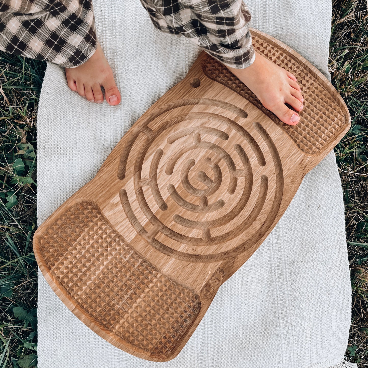 Child using the Neuro Balance Board ‘Sacred Labyrinth’ for balance training, promoting physical and mental growth.