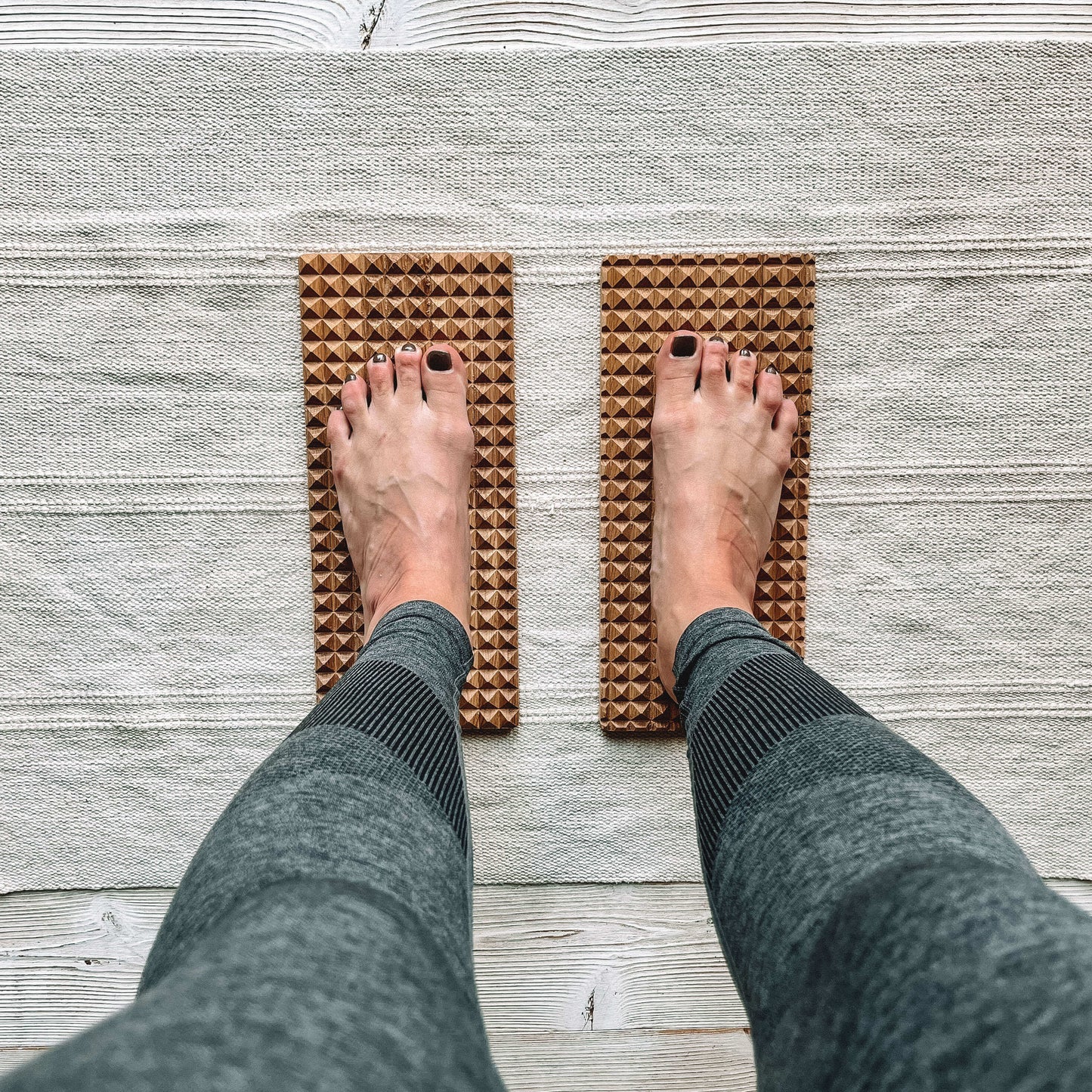 Person using the Wooden Oak Sadhu Board during a yoga session for grounding and energy balance.