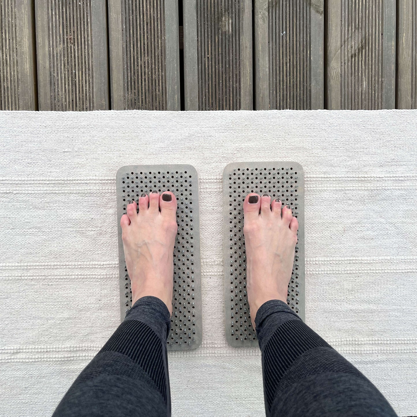 A person standing on the Sadhu nail board during meditation practice.